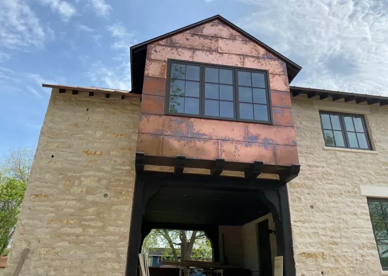 Copper metal panel facade on a stone building for Skylight Installation in Isanti